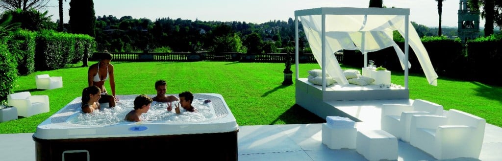 Un jardin decorado con Jacuzzi, mesas y sillas chics